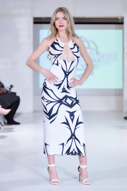 Model wearing a white dress with black geometric patterns on a runway