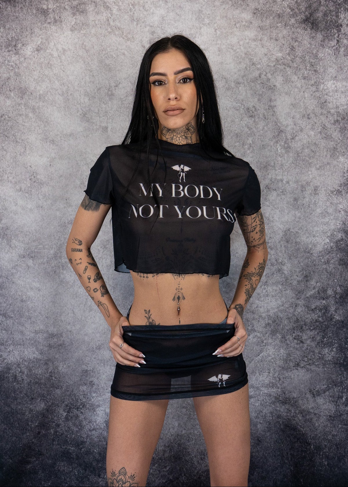 Person wearing a black crop top with 'My Body, Not Yours' text against a textured gray background